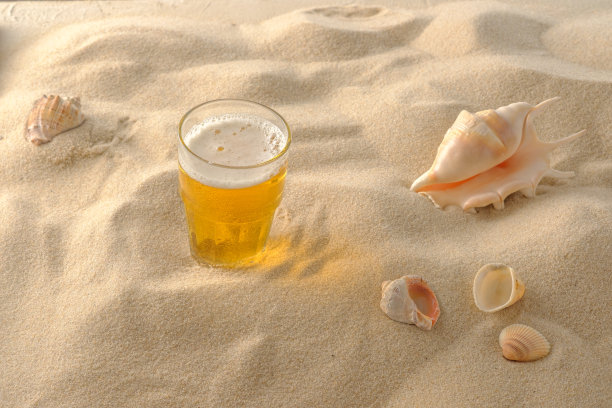 海滩度假的概念。沙滩上的冷饮。冰冷的啤酒泡沫。特写镜头。图片下载