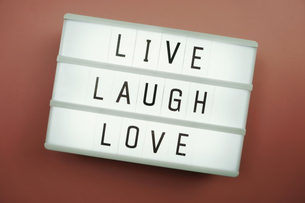 活笑爱字在灯箱平躺在粉红色的背景上图片下载