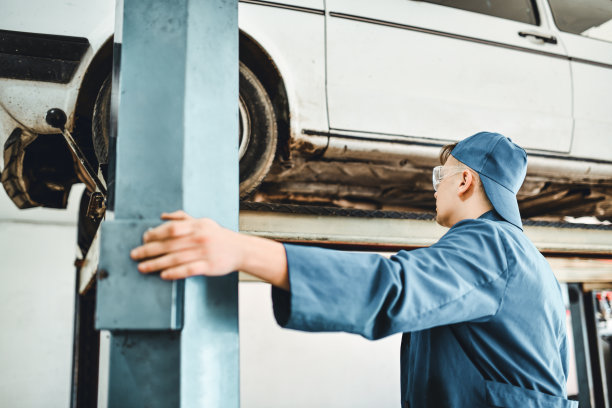 年轻机械师对液压电梯升降车进行检查图片下载