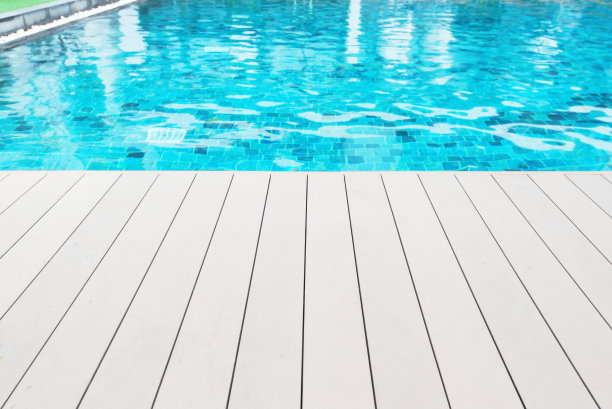 游泳池旁边的空木制平台图片下载