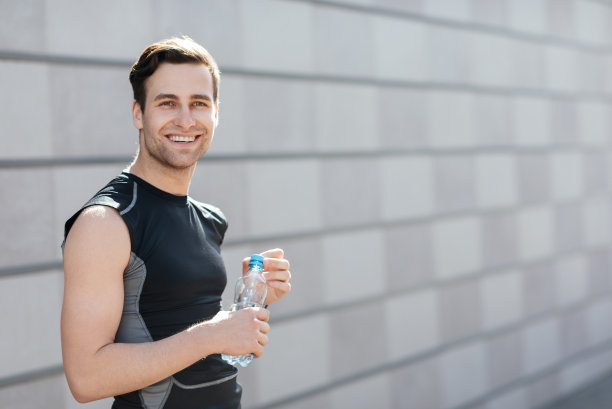热爱运动，为马拉松做准备。一个穿着运动服，拿着一瓶水的人图片下载