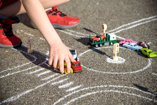 有趣的孩子男孩有乐趣与图画画交通汽车与粉笔。夏季户外儿童的创造性休闲活动。复杂的交通规则概念图片下载
