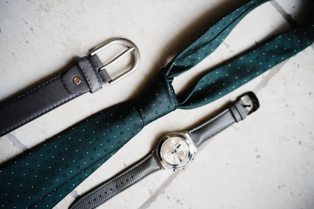 男士的腰带、领带和手表放在一块轻石上。图片下载