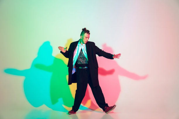 年轻漂亮的男子跳舞嘻哈，街头风格孤立在工作室背景霓虹灯图片下载