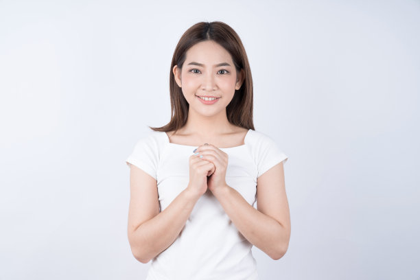 年轻美丽快乐的亚洲女人与笑脸孤立在白色的背景。素材图片