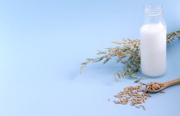 燕麦牛奶在一个玻璃瓶与燕麦在一个蓝色的背景，复制空间，水平图像图片下载