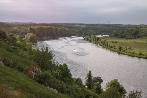 在自然保护区，一艘快速行驶的摩托艇载着游客俯瞰河流。渔民们坐船去捕鱼。美丽的漂亮的风景。库存图片图片下载