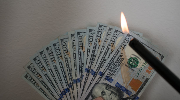 燃烧金钱主题-扇百元纸币与火和打火机图片下载