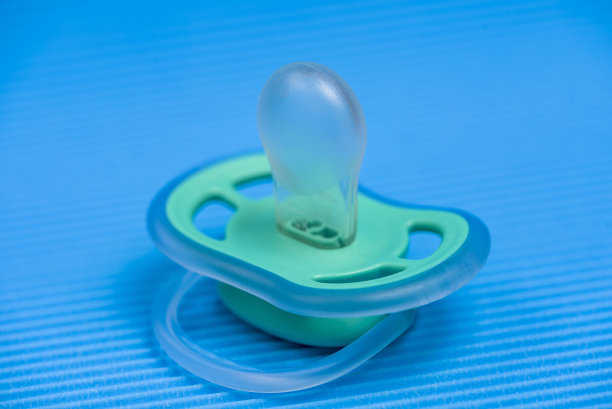 蓝色背景上的奶嘴和拨浪鼓图片下载