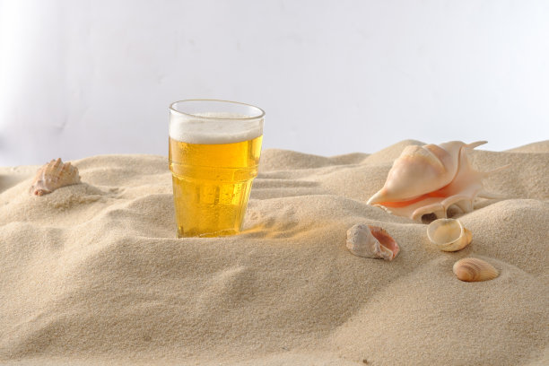 海滩度假的概念。沙滩上的冷饮。冰冷的啤酒泡沫。特写镜头。图片下载