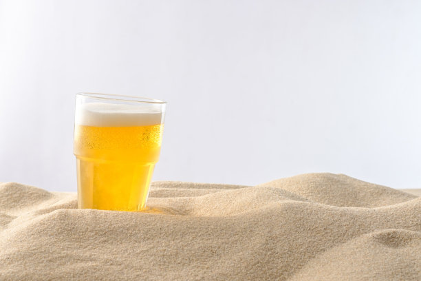 海滩度假的概念。沙滩上的冷饮。冰冷的啤酒泡沫。特写镜头。图片下载
