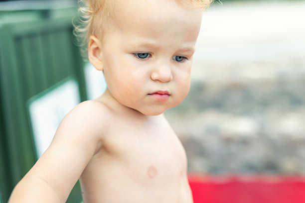 可爱的沉思不安的2岁白种人蹒跚学步的男孩肖像独自站在海滩夏天的一天，看一边。孩子带着遥远的目光。思考生活和未来的孩子图片下载