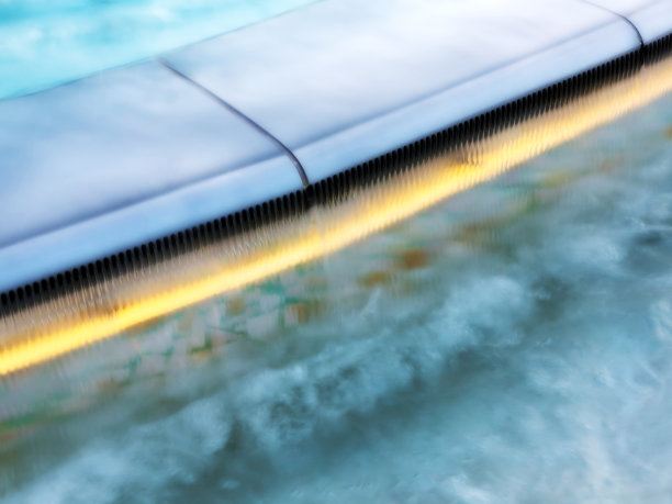 清澈和干净的水在池的背景。模糊的表面上的波浪。图片下载