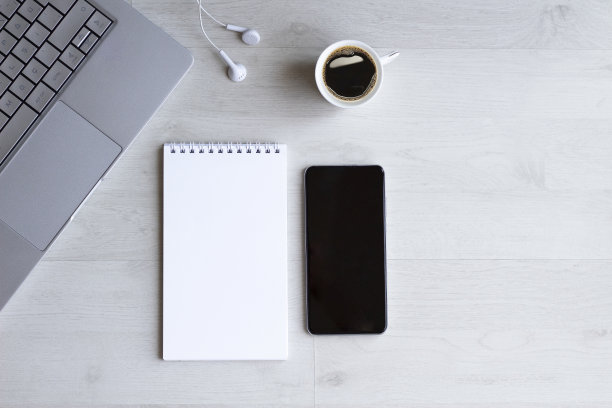 办公桌桌上有笔记本电脑，笔记本电脑，电话，咖啡杯和耳机图片下载