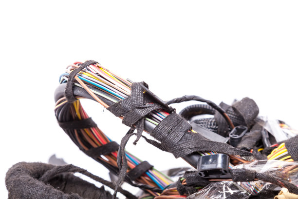 不同颜色、大小和类型的扭曲的电线，用黑色的电子胶带重新缠绕，近距离地对抗一团缠结的电源通道。头痛电源工程师或安装人员诊断互联网图片下载