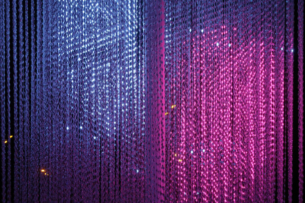 悬挂着带粉色和蓝色斑点的led灯绳。夜间城市照明。图片下载