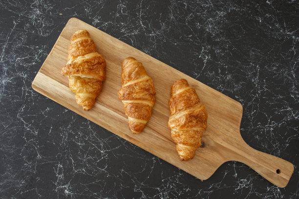 牛角面包放在木桌上，孤立的背景图片下载