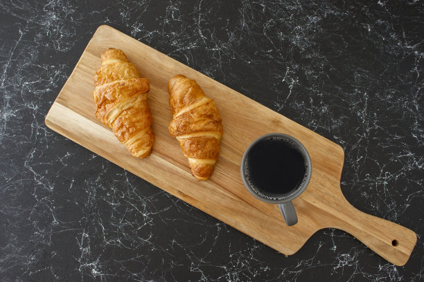 牛角面包和过滤咖啡放在木桌上，孤立的背景图片下载