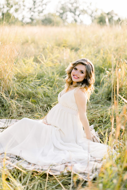 户外夏天的照片美丽的怀孕金发女孩在白色的连衣裙，坐在和休息在一个格子毯子在夏天阳光灿烂的田野图片下载