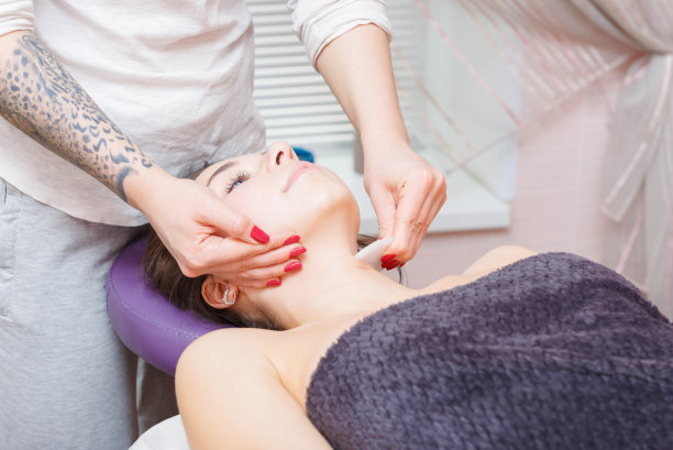 主人给客人做面部按摩。图片下载