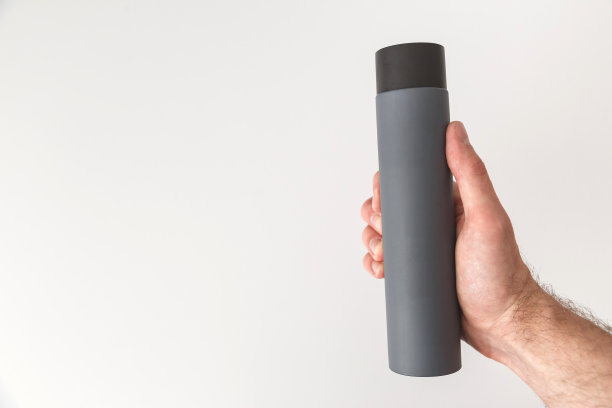 灰色洗发水或洗液瓶在男性手上孤立在白色背景上。复制空间，模拟。图片下载