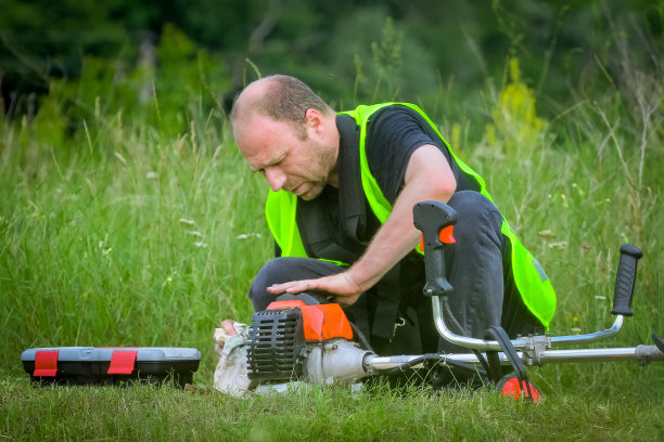 体力劳动者割高草，用刈草机除草图片下载