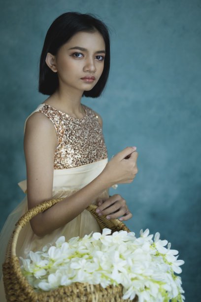 肖像美丽的年轻女孩与花和绿色复古背景。图片下载