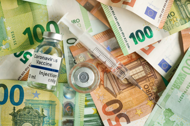 新冠肺炎疫苗的价格/成本概念——一堆欧元钞票上有银盖子的玻璃瓶，旁边有注射器，特写细节(带有假数据的自己的贴纸设计——不是真正的产品)图片下载