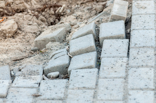 人行道上有个大洞。人行道是用砖铺的。人行道上崩溃。图片下载