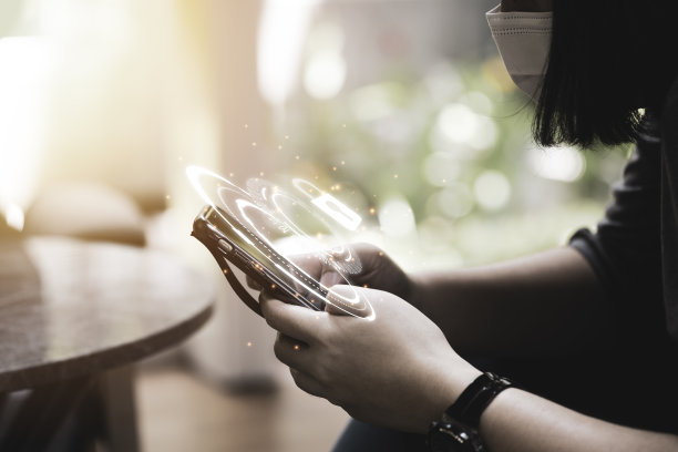 女人戴着外科口罩，输入安全密码进入智能手机。安全与技术概念。图片下载