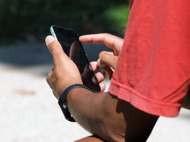 男人的手在外面使用智能手机图片下载