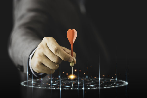 商人持有和投掷红色飞镖虚拟目标飞镖板。为企业投资概念设定目标和目标。图片下载