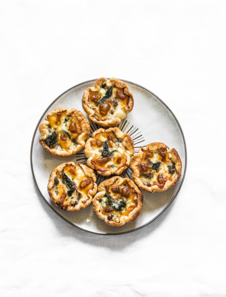 肉末，菠菜，马苏里拉奶酪迷你手派的开胃菜，小吃，小吃在一个轻的背景，俯视图图片下载