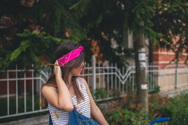 微笑的女人骑着自行车在城镇的街道上图片下载