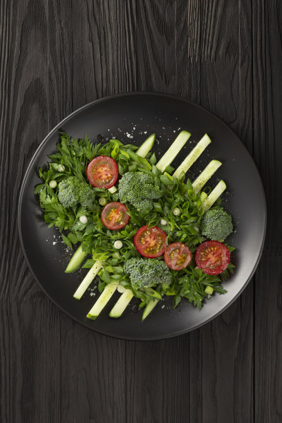 蔬菜沙拉深色浅盘设计高级菜肴。低调拍照图片下载
