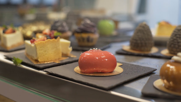 蛋糕店的橱窗里陈列着各种各样的蛋糕。糕点店的松饼，泡芙，蛋糕与水果，浆果图片下载