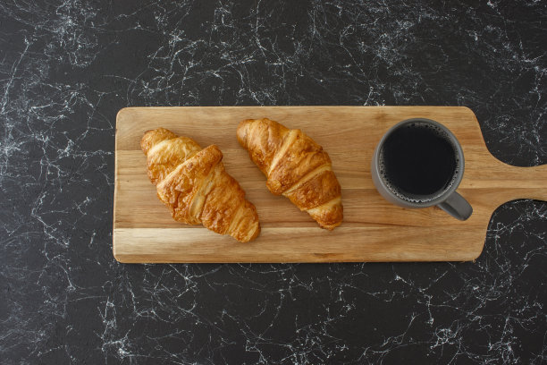 牛角面包和过滤咖啡放在木桌上，孤立的背景图片下载