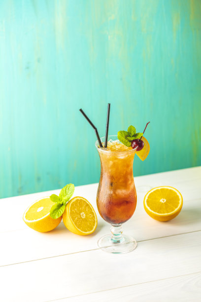 性在海滩鸡尾酒在玻璃与水滴在绿松石背景。特写，浅景深的领域，复制空间为您的文本。图片下载