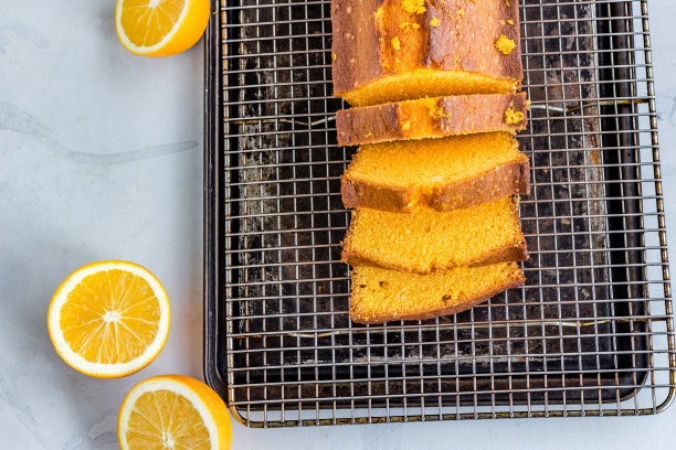 橙色磅蛋糕和切片在烤盘上的白色背景自上而下平躺照片图片下载