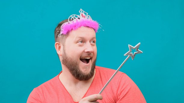 一名身穿粉色t恤、头上戴着盲童、长着胡子的古怪男子梦见自己手里拿着一根魔杖。一个有趣的巫师笑话，用来实现一个愿望图片下载