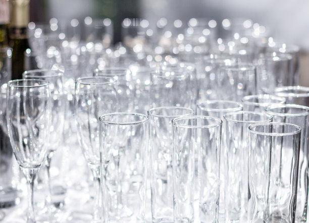 桌子上有很多不同的空杯子。为宴会、假日或婚礼做准备。模糊的背景。图片下载