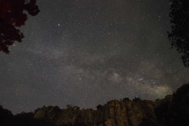 雄伟而美丽的银河与山框架和树木。图片下载