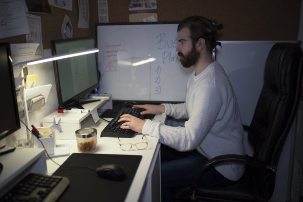 男人使用电脑，在家里办公室工作到深夜图片下载