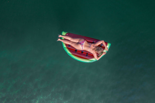 鸟瞰图上的女人漂浮在湖上充气床垫日光浴图片下载
