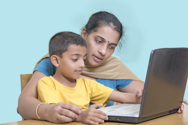 8岁男孩和他妈妈一起上网络课图片下载