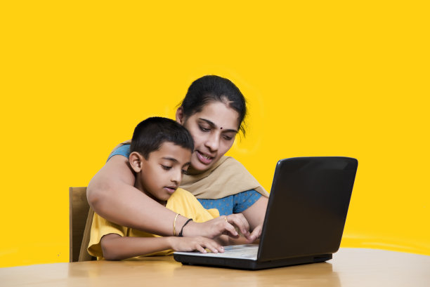 8岁男孩和他妈妈一起上网络课图片下载