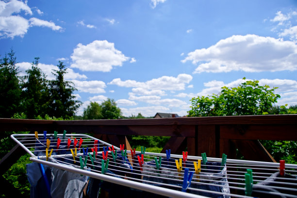 烘干机和彩色衣夹，阳台上的衣服在一个晴朗的日子图片下载
