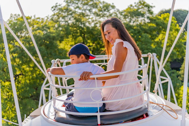 快乐的母亲和儿子在游乐园的肖像图片下载