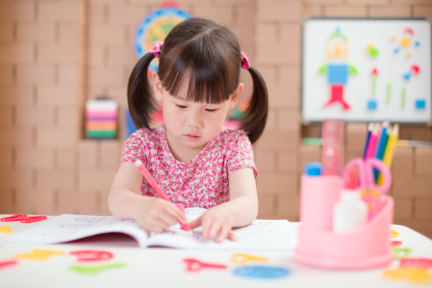 蹒跚学步的小女孩练习写作，在家上学图片下载