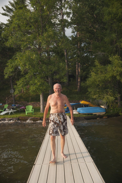 一个老人走在湖边的码头上图片下载